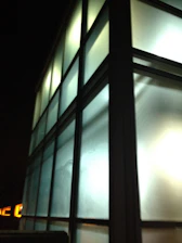 A sleek, photorealistic 3D image of a modern architectural building glowing under soft natural light.