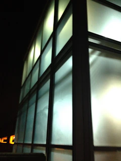 A sleek glass-panelled building glowing softly under a twilight sky, symbolizing innovation and growth.