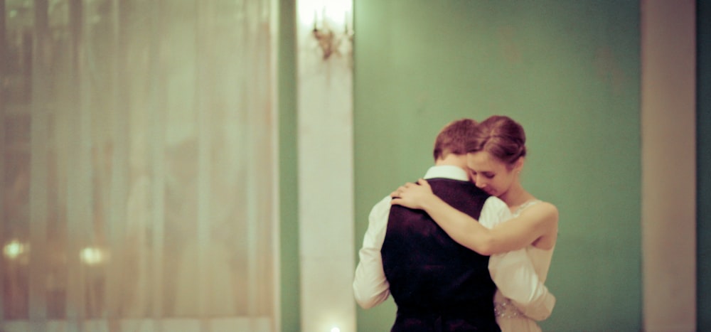 Bride and groom dance quietly together in a green-painted room