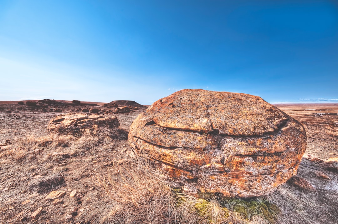 brown rock on deserted land under blue sky during daytime