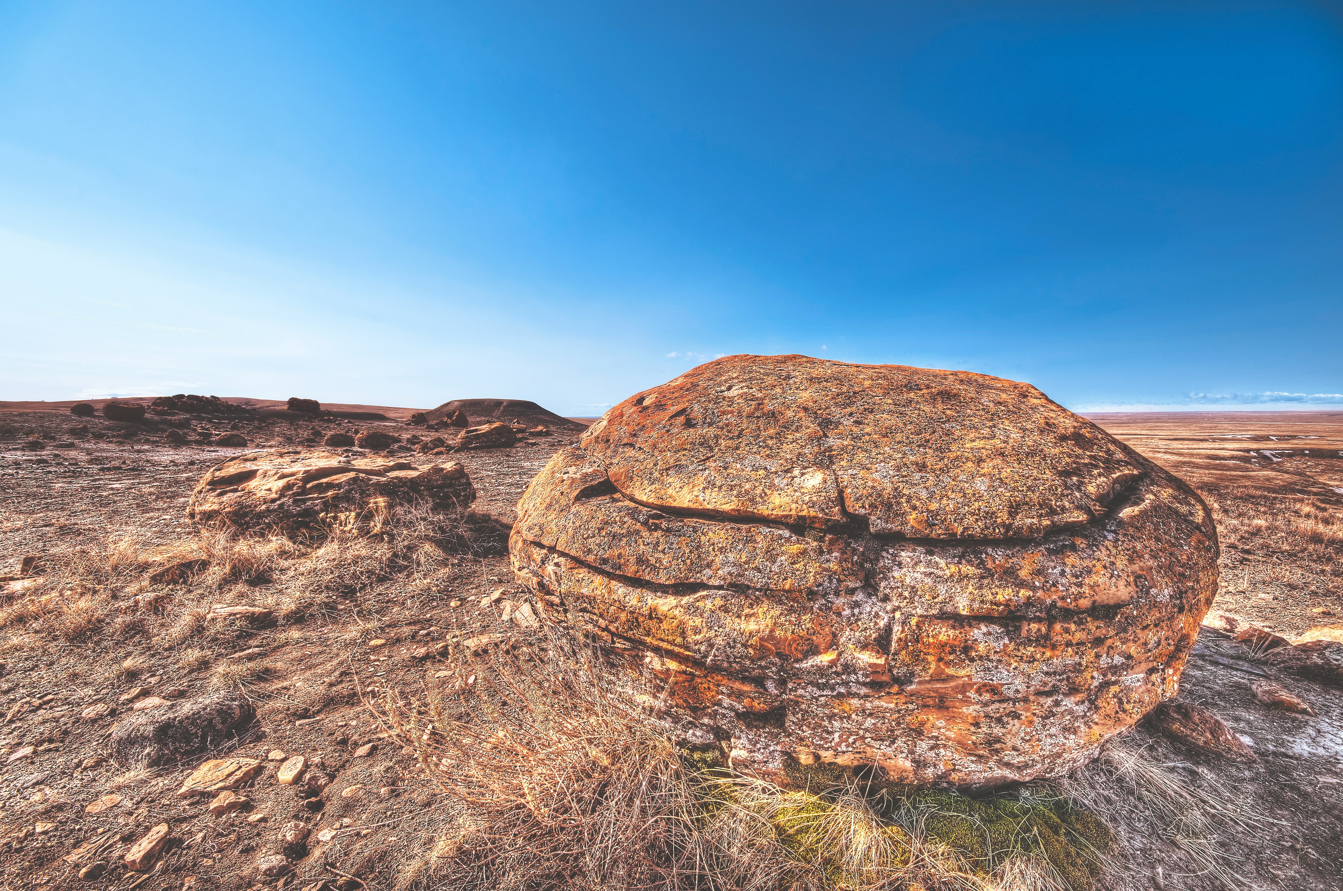 brown rock on deserted land under blue sky during daytime