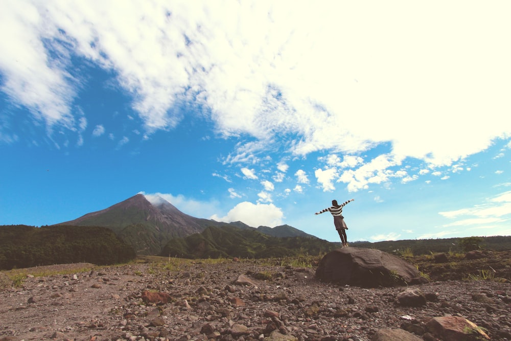 person standing on boulder