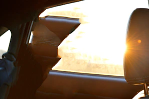 Artistic shot of sunlight filtering through tinted car windows highlighting the film texture