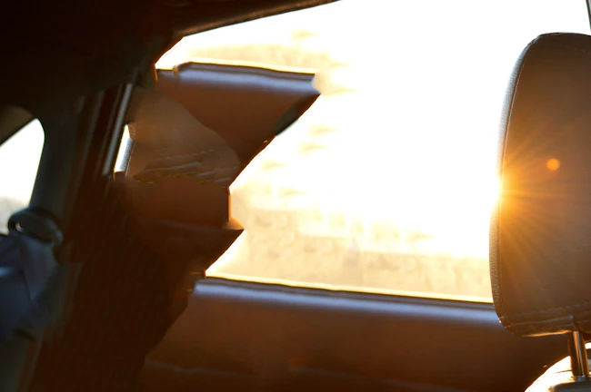 A cozy car interior with soft sunlight streaming through the windows, highlighting a stylish seat cover.
