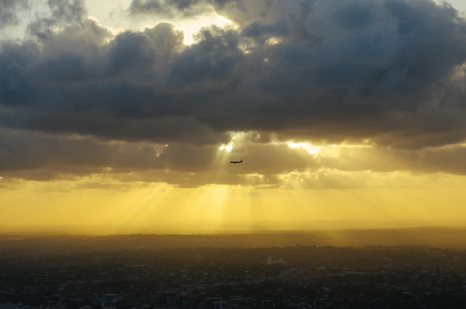 Silueta de un avión volando bajo un cielo de nubes densas