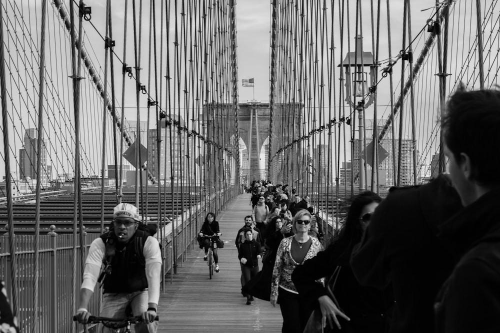 Foto in scala di grigi di persone sul ponte