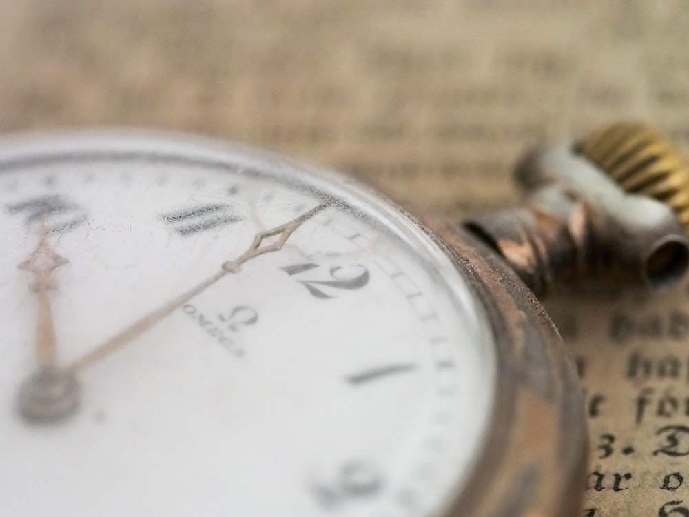 closeup photo of gold-colored pocket watch