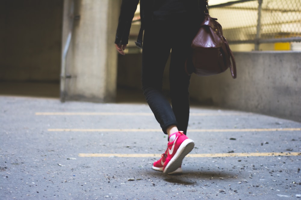 person wearing Nike running shoes walking along the path