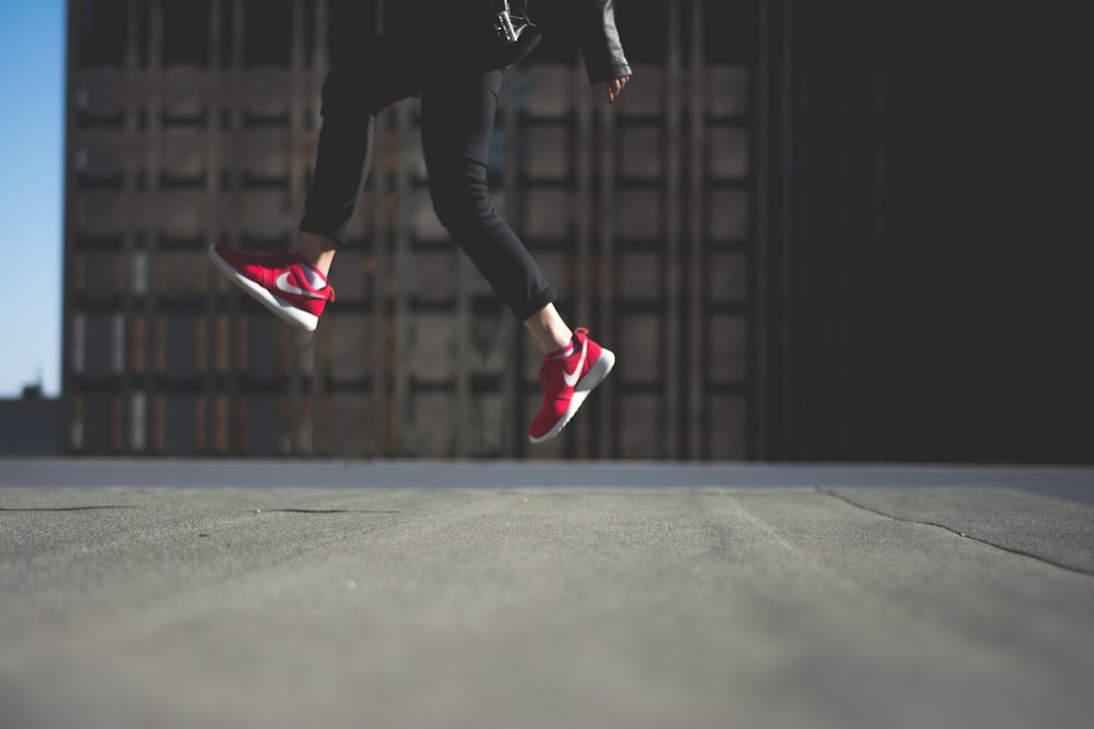 person wearing pair of red Nike shoes