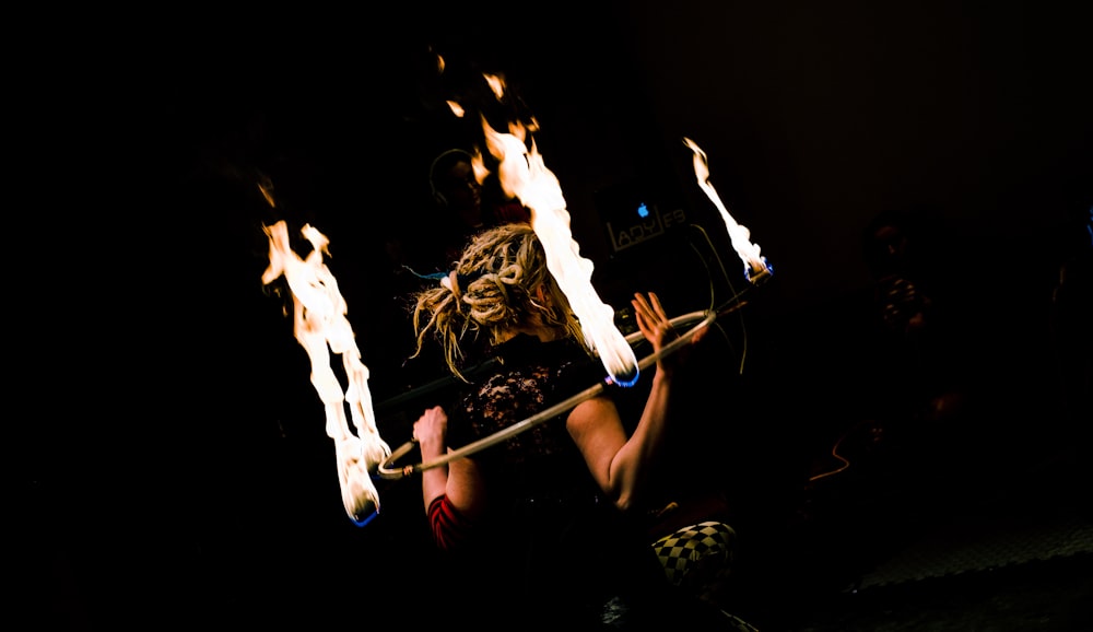 Mujer sosteniendo hula-hoop con fuego
