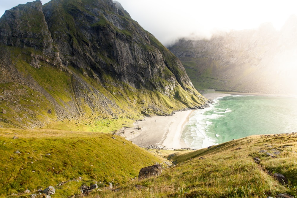 landscape photography of beach surrounded by mountains