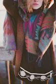 Model wearing a poncho walking through a colorful market street in Ecuador.