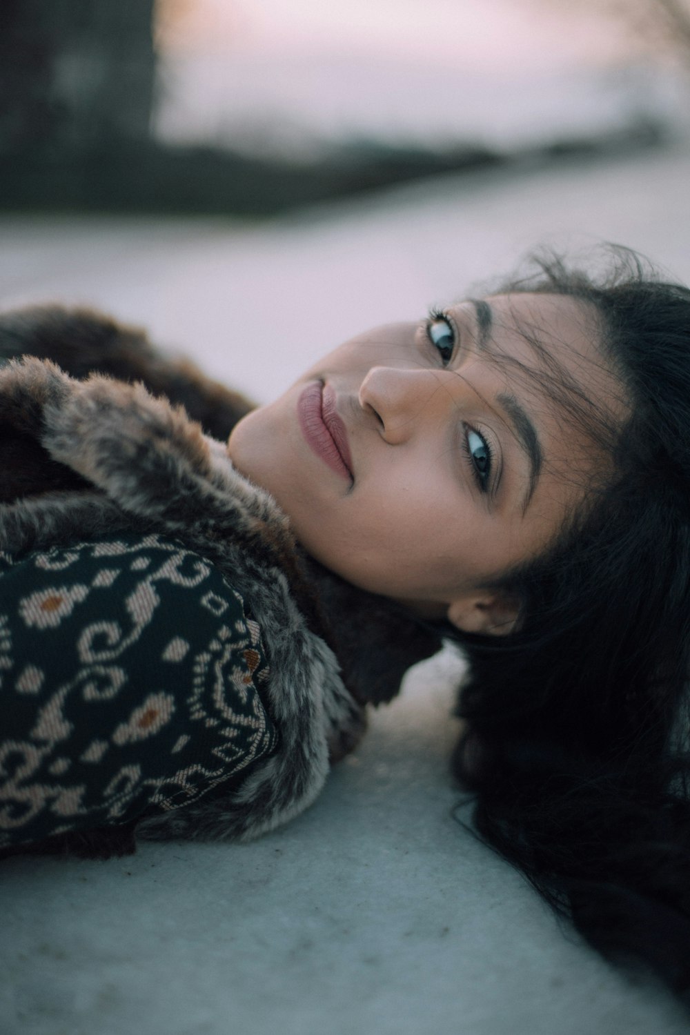 selective focus photo of woman lying on ground smiling