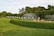A satisfied customer standing in a beautifully landscaped yard with an irrigation system.