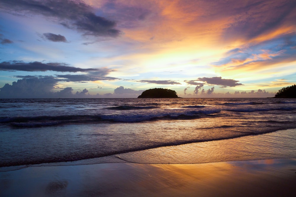 photo of island on ocean during golden hour