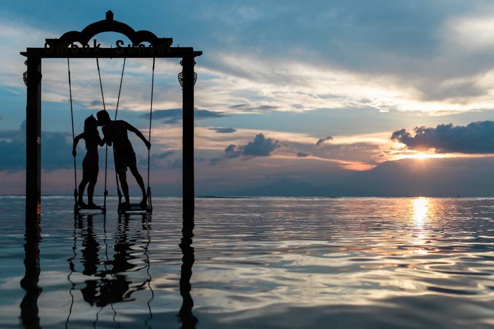 um casal em pé no mar enquanto se beija
