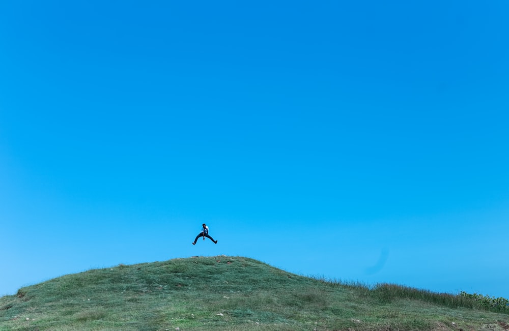 man jumping on cliff at daytime