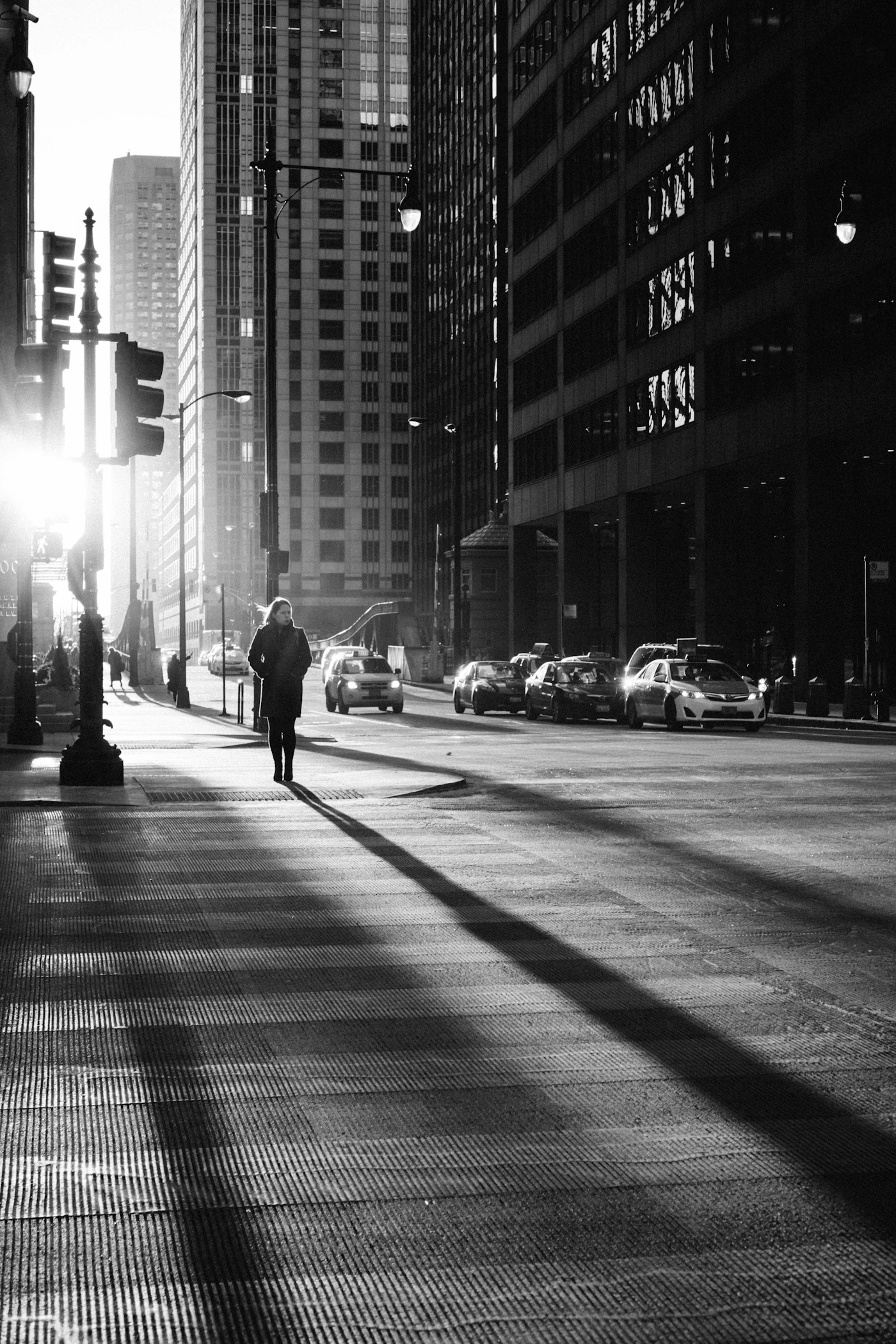 Black and white street photograph with a person walking on a road