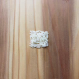 Close-up of golden long grain white rice neatly piled in a rustic wooden crate.