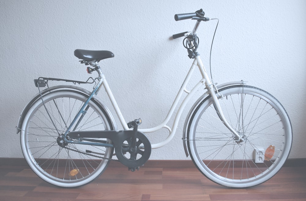 bicicleta cruiser branca no piso de parquet marrom