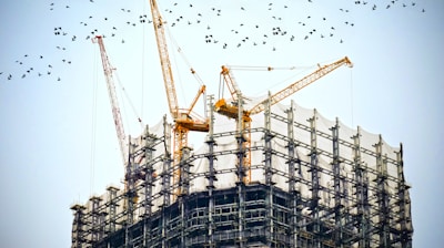 low angle photography of cranes on top of building