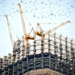 low angle photography of cranes on top of building