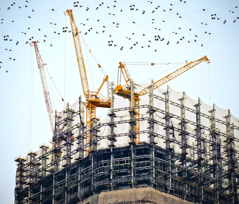 low angle photography of cranes on top of building