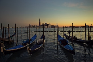 Colorful gondolas floating on the canals of Venice at dusk.
