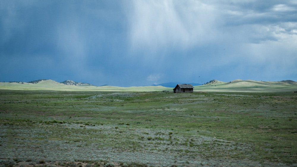 Campo de grama verde sob céu nublado branco durante o dia