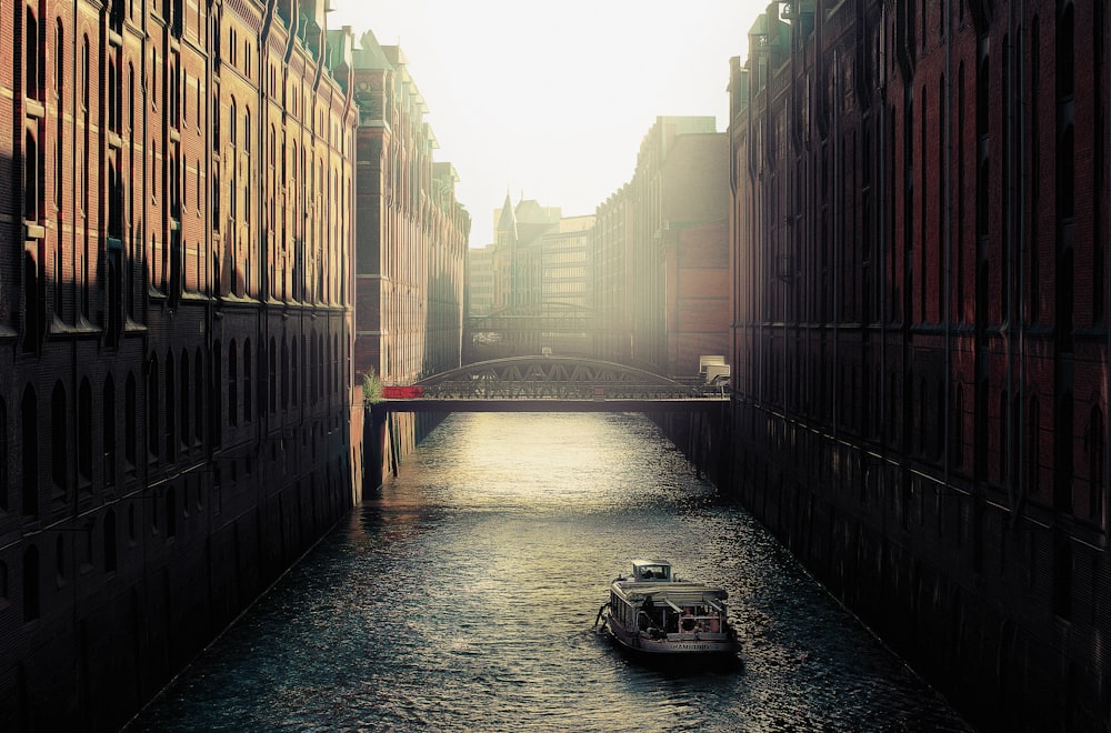 boat on body of water between highrise buildings