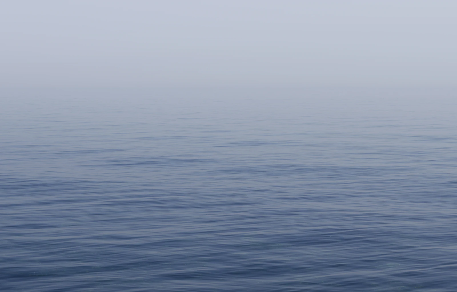 yoni practice — a calm water surface under an overcast sky