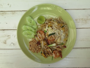 A vibrant plate of Pad Thai garnished with lime.