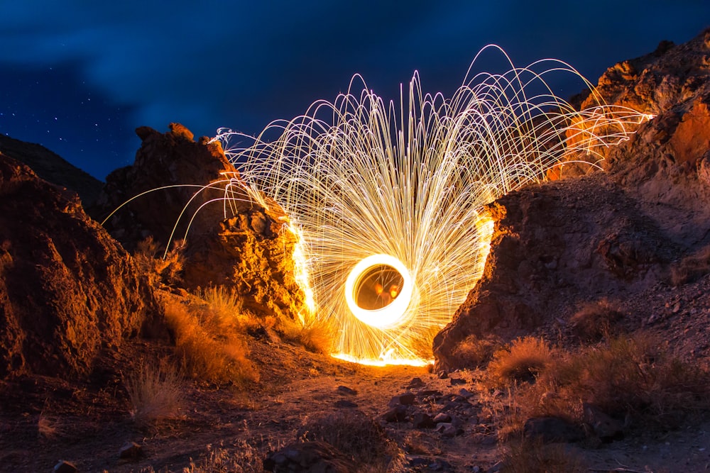 Bright spiral firework at night in mountains on dusty landscape