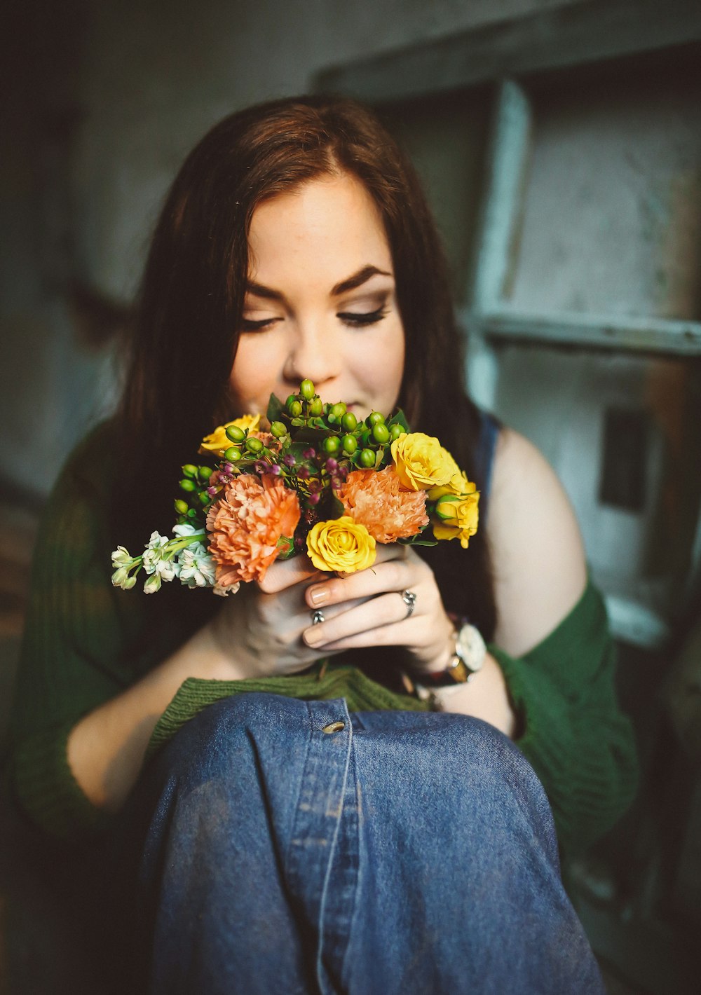 Mujer con falda de mezclilla azul sosteniendo flores