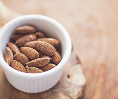shallow focus photography of almonds in white ceramic bowl