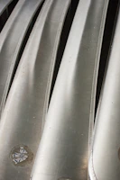 Close-up of polished steel sheets reflecting light in a factory setting