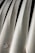 A close-up view of several metallic structures aligned in parallel, with a smooth and shiny surface. There are visible bolts or rivets along the edges of the metallic panels, and the surface reflects light at various angles.