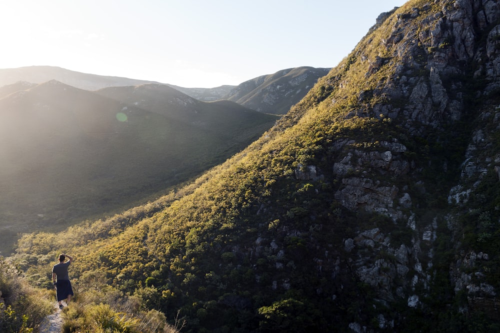 person standing on top of hill during day time