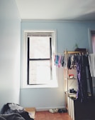 A bright bedroom with space-saving furniture and clothes hung in an orderly fashion