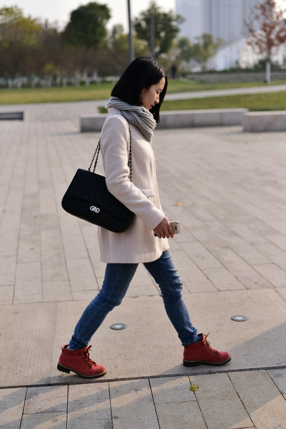 woman walking while holding smartphone