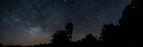 Panoramic shot of the night sky filled with constellations and the Milky Way