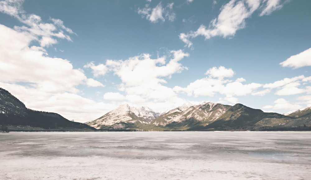 brown and white mountains near sand during daytime