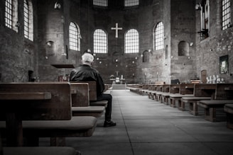 person sitting on pew inside church