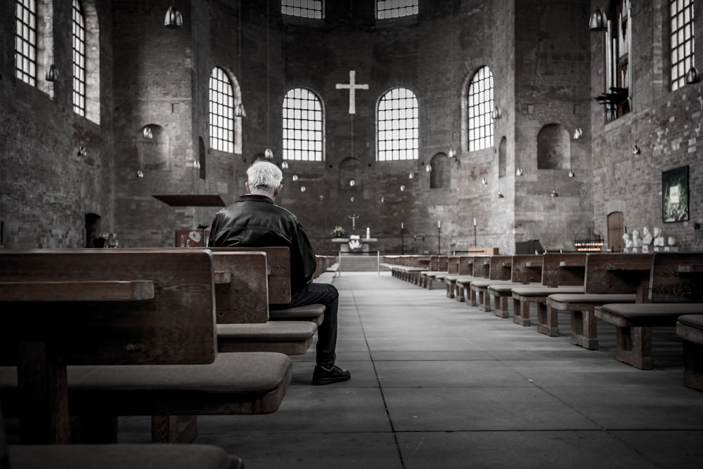 person sitting on pew inside church