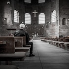 person sitting on pew inside church