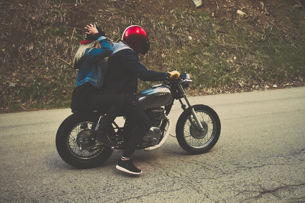 Blacktop Road에서 순양함 오토바이를 타고 있는 남자와 여자