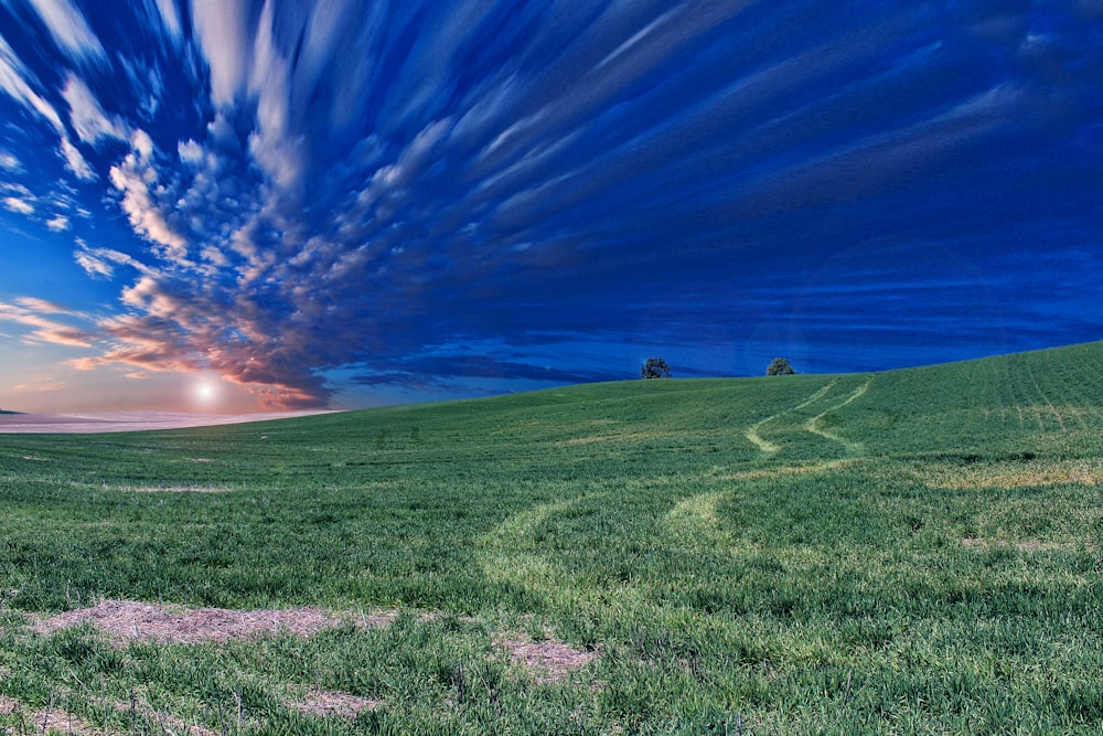 time lapse photography of green field and clouds
