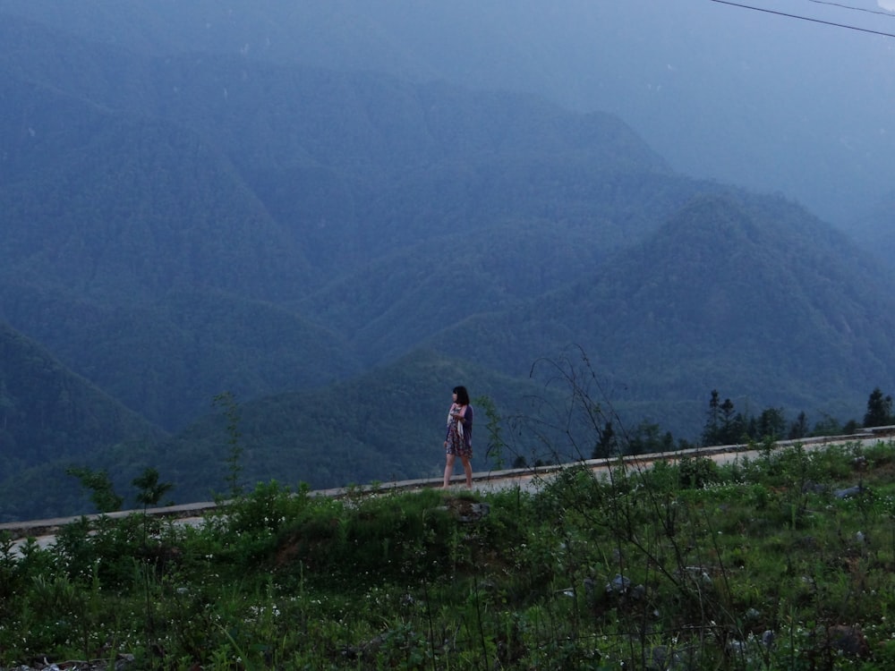 femme debout près de la montagne pendant la journée
