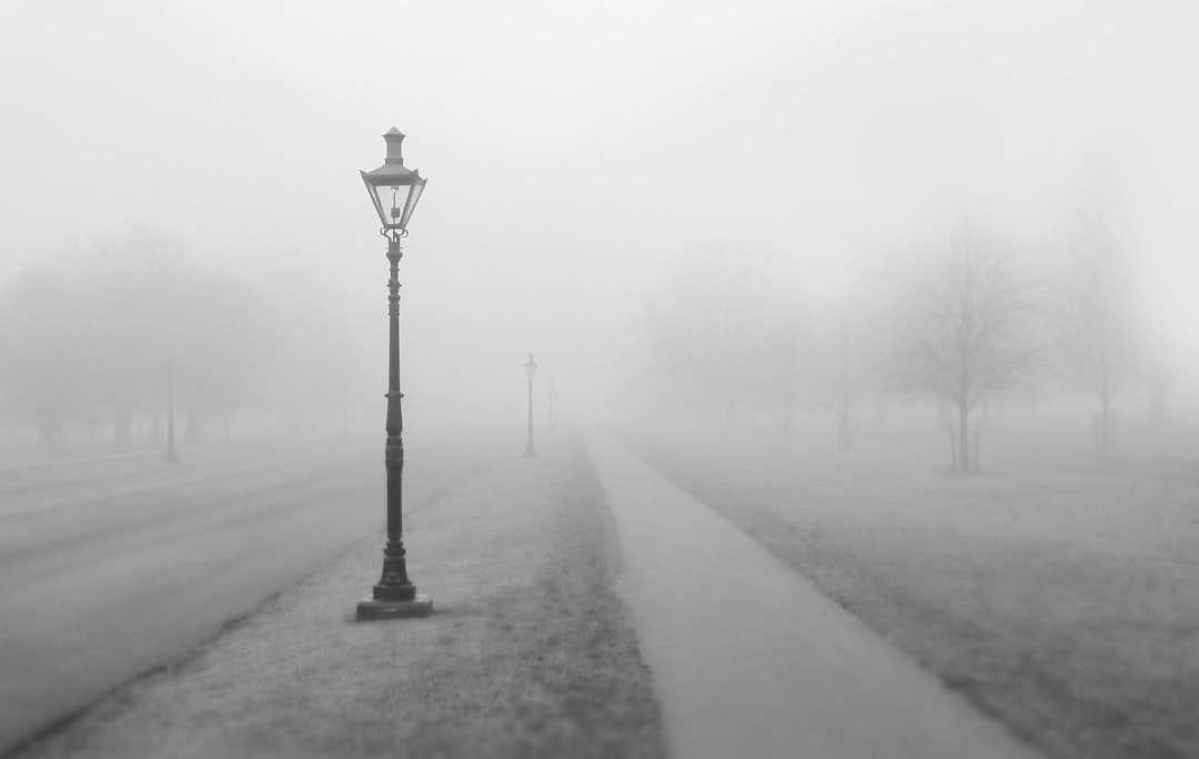 grayscale photo of street post with smoke