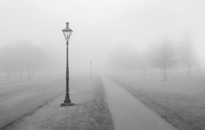 grayscale photo of street post with smoke fog zoom background